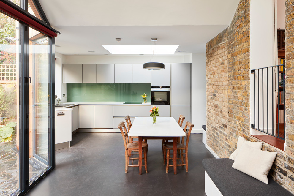 Offene Moderne Küche ohne Insel in L-Form mit flächenbündigen Schrankfronten, grauen Schränken und grauem Boden in London