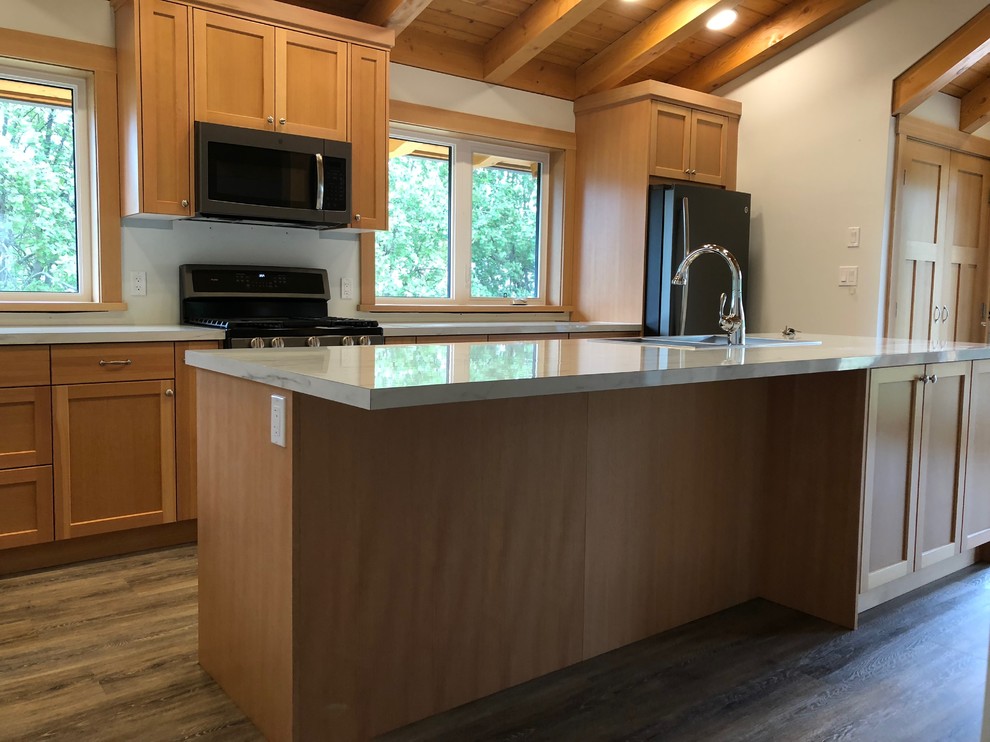 Photo of a small traditional l-shaped kitchen/diner in Vancouver with a built-in sink, shaker cabinets, laminate countertops, black appliances, laminate floors, an island, grey floors and white worktops.
