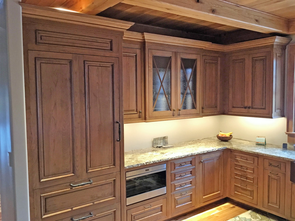 Foto di una cucina rustica di medie dimensioni con lavello stile country, ante a filo, ante in legno chiaro, top in granito, elettrodomestici da incasso e parquet chiaro
