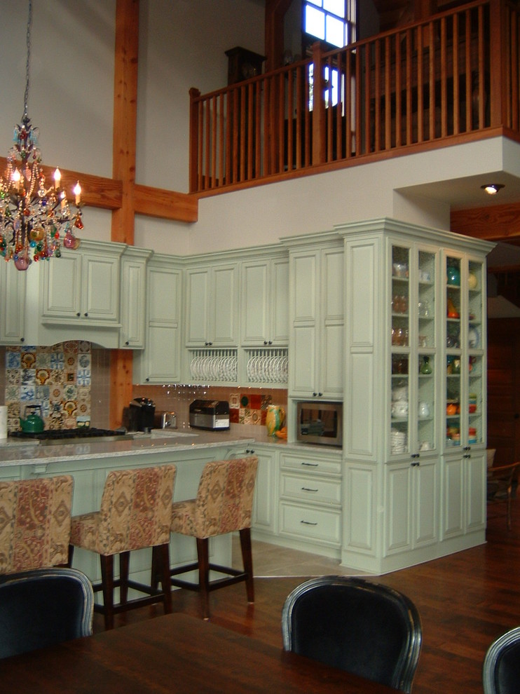 Immagine di una cucina country di medie dimensioni con ante con bugna sagomata, ante blu, top in granito, elettrodomestici in acciaio inossidabile, parquet scuro e pavimento marrone