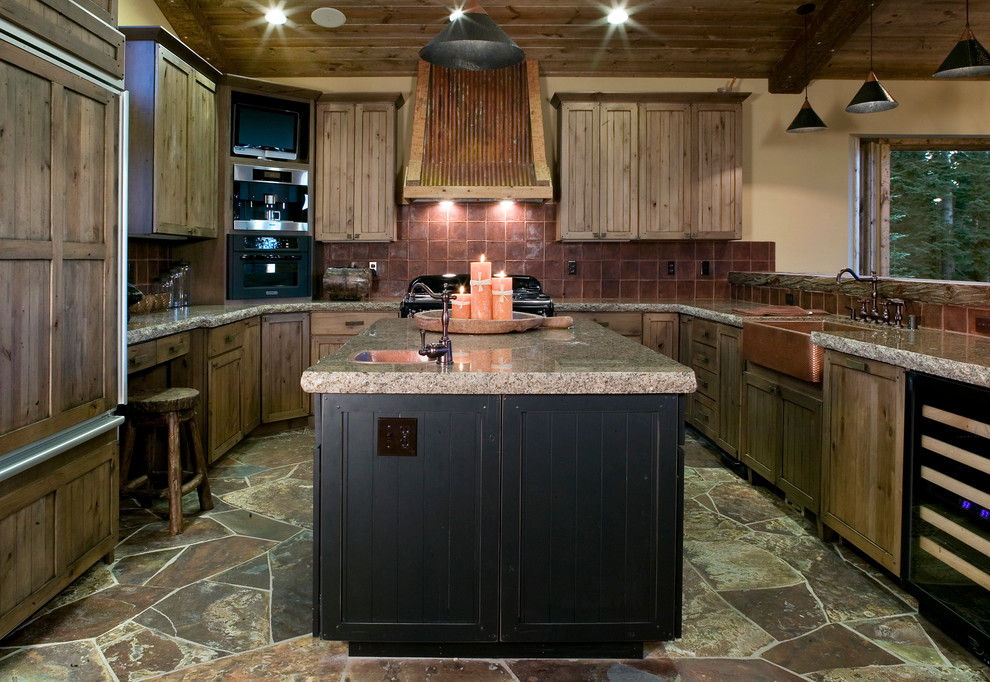 Imagen de cocinas en U rural con fregadero sobremueble, armarios estilo shaker, puertas de armario de madera oscura, salpicadero marrón y electrodomésticos con paneles