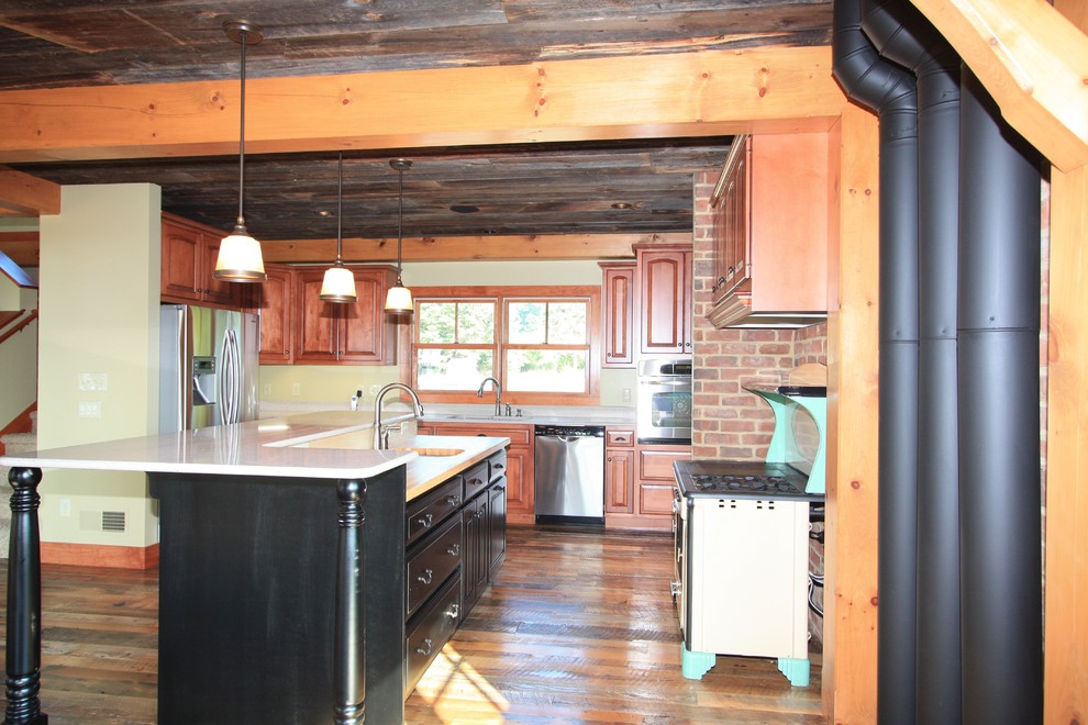 This is an example of a medium sized traditional u-shaped kitchen/diner in Other with a double-bowl sink, raised-panel cabinets, medium wood cabinets, composite countertops, stainless steel appliances, medium hardwood flooring and an island.
