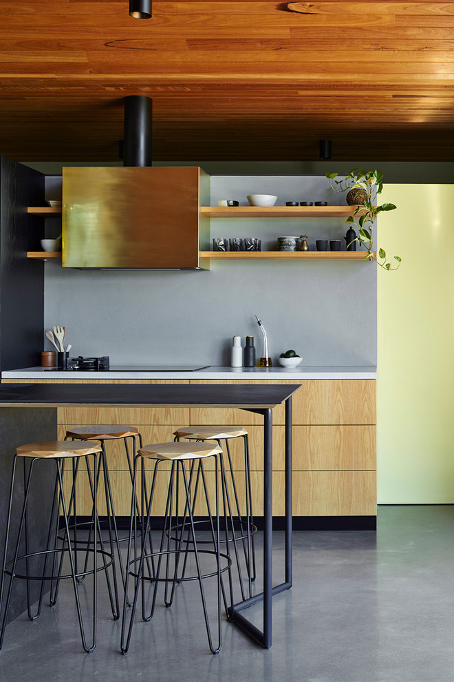 This is an example of a medium sized urban galley kitchen in Adelaide with flat-panel cabinets, light wood cabinets, cement tile splashback and an island.
