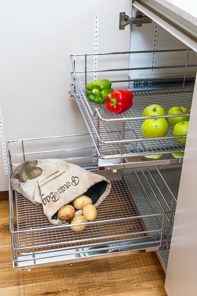 Immagine di una cucina contemporanea di medie dimensioni con lavello integrato, ante lisce, ante grigie, top in superficie solida e elettrodomestici in acciaio inossidabile