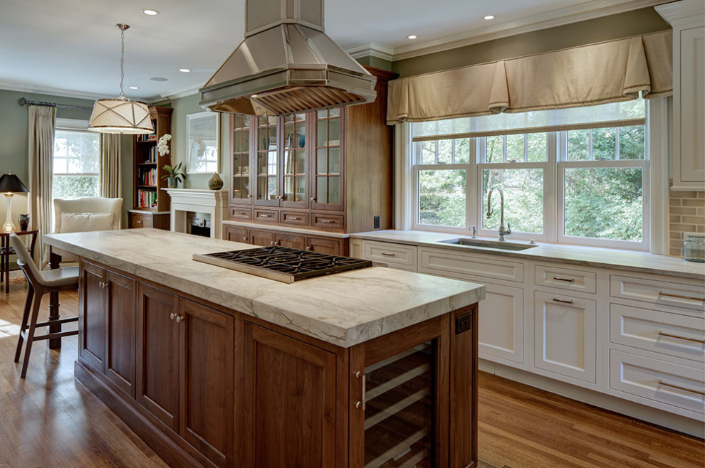 Imagen de cocinas en L clásica con armarios estilo shaker, electrodomésticos con paneles, suelo de madera en tonos medios, una isla y encimeras beige