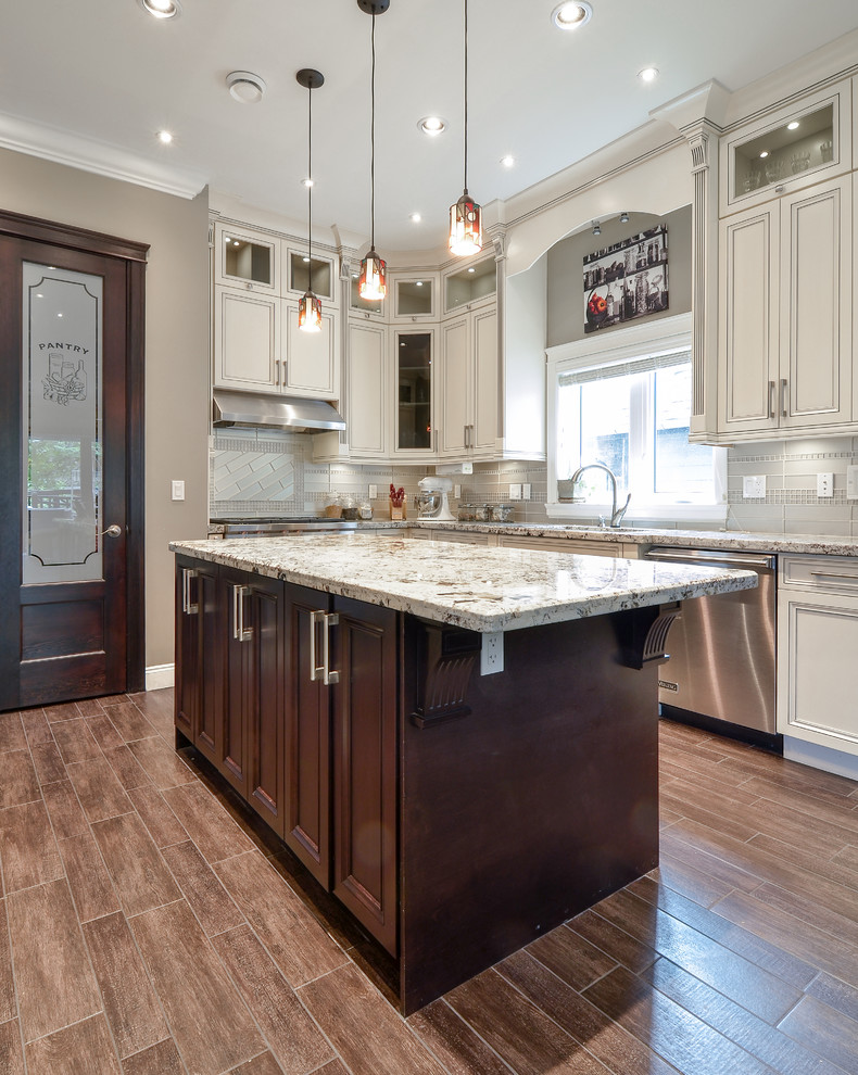 Inspiration for a large contemporary l-shaped light wood floor enclosed kitchen remodel in Vancouver with recessed-panel cabinets, white cabinets, an island, an undermount sink, granite countertops, glass tile backsplash, stainless steel appliances and gray backsplash