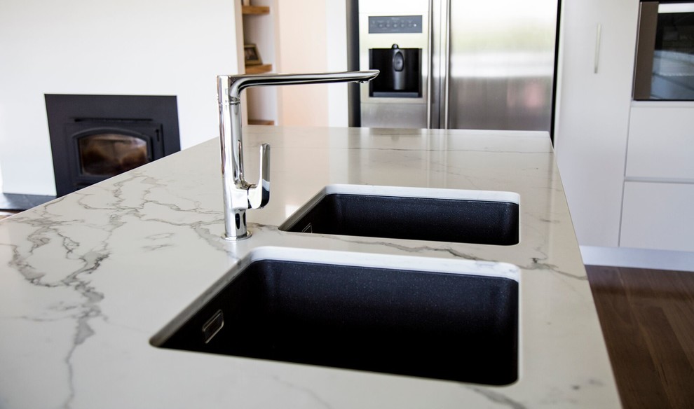 Idee per una cucina contemporanea con lavello sottopiano, ante lisce, ante bianche, top in marmo, elettrodomestici in acciaio inossidabile e parquet chiaro