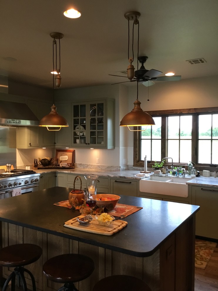 Offene, Mittelgroße Shabby-Style Küche in U-Form mit Doppelwaschbecken, Kassettenfronten, grünen Schränken, Küchengeräten aus Edelstahl, braunem Holzboden und Kücheninsel in Oklahoma City