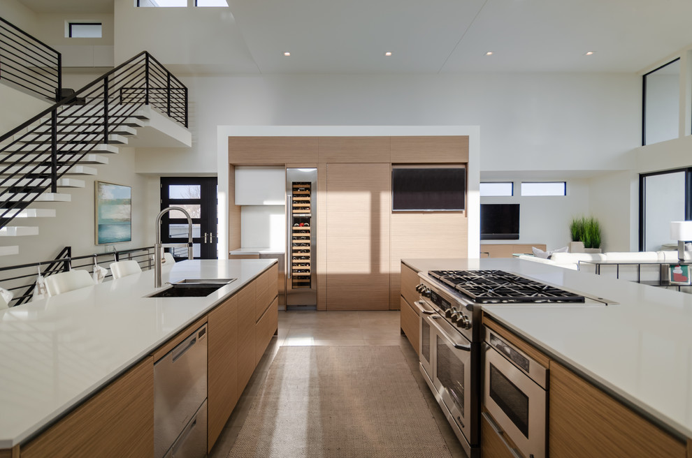 Example of a huge trendy concrete floor and gray floor open concept kitchen design in Other with an undermount sink, flat-panel cabinets, medium tone wood cabinets, quartz countertops, white backsplash, glass sheet backsplash, stainless steel appliances, two islands and white countertops