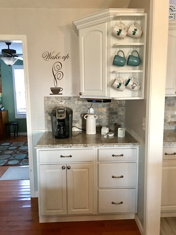 Eat-in kitchen - mid-sized single-wall eat-in kitchen idea in Other with an undermount sink, raised-panel cabinets, dark wood cabinets, granite countertops, multicolored backsplash, subway tile backsplash, stainless steel appliances and an island