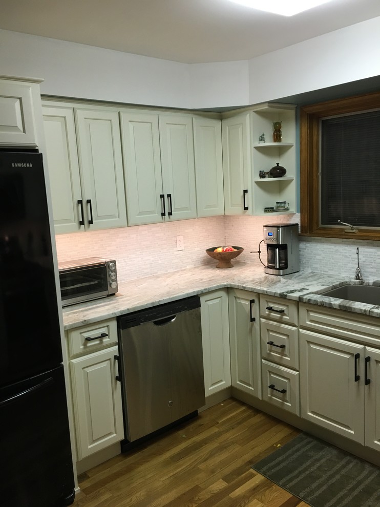 Foto på ett litet funkis kök, med en undermonterad diskho, luckor med upphöjd panel, granitbänkskiva, vitt stänkskydd, glaspanel som stänkskydd, rostfria vitvaror, mellanmörkt trägolv och brunt golv