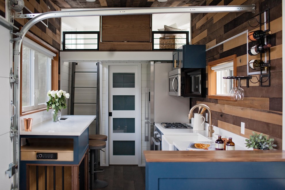 Einzeilige Moderne Wohnküche mit Landhausspüle, Schrankfronten im Shaker-Stil, blauen Schränken, Küchenrückwand in Braun, Rückwand aus Holz, Küchengeräten aus Edelstahl, dunklem Holzboden, braunem Boden und weißer Arbeitsplatte in Portland