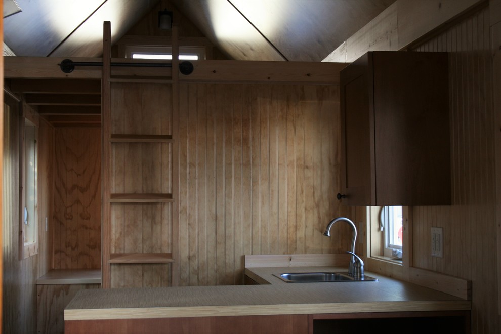 Bild på ett litet rustikt kök, med laminatbänkskiva och rostfria vitvaror