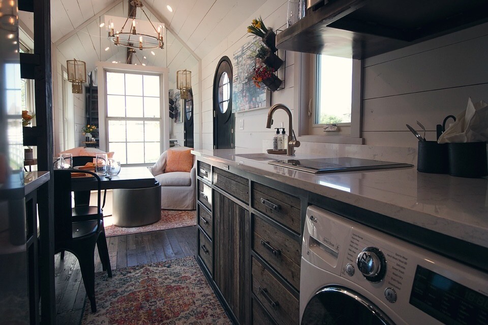 Réalisation d'une petite cuisine ouverte linéaire tradition en bois brun avec un évier encastré, un placard à porte plane, parquet foncé, aucun îlot et machine à laver.