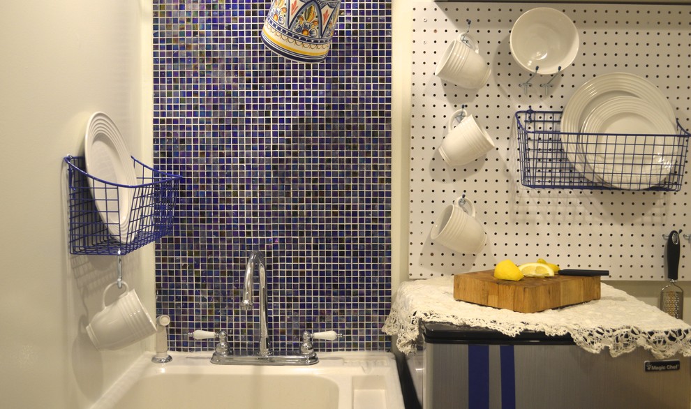 Foto di una piccola cucina abitabile mediterranea con nessun'anta, paraspruzzi blu, paraspruzzi con piastrelle in ceramica e pavimento in cemento
