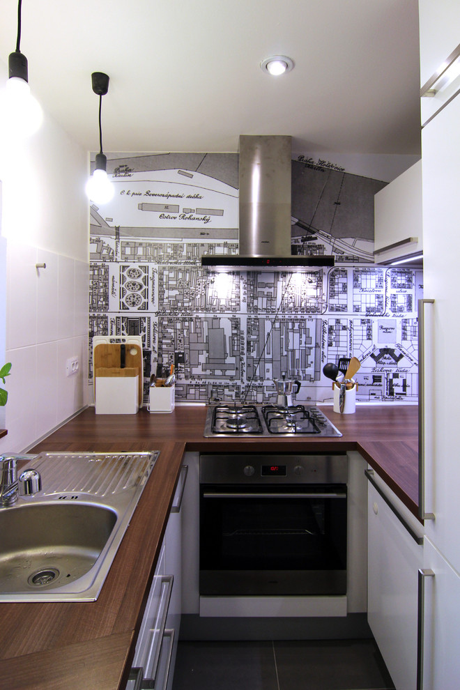 Exempel på ett avskilt, litet modernt u-kök, med en enkel diskho, släta luckor, vita skåp, laminatbänkskiva, rostfria vitvaror och klinkergolv i keramik