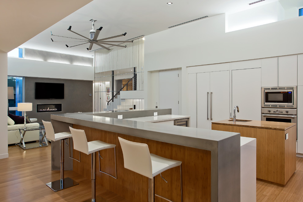 Offene Moderne Küche mit flächenbündigen Schrankfronten, weißen Schränken und Elektrogeräten mit Frontblende in Tampa