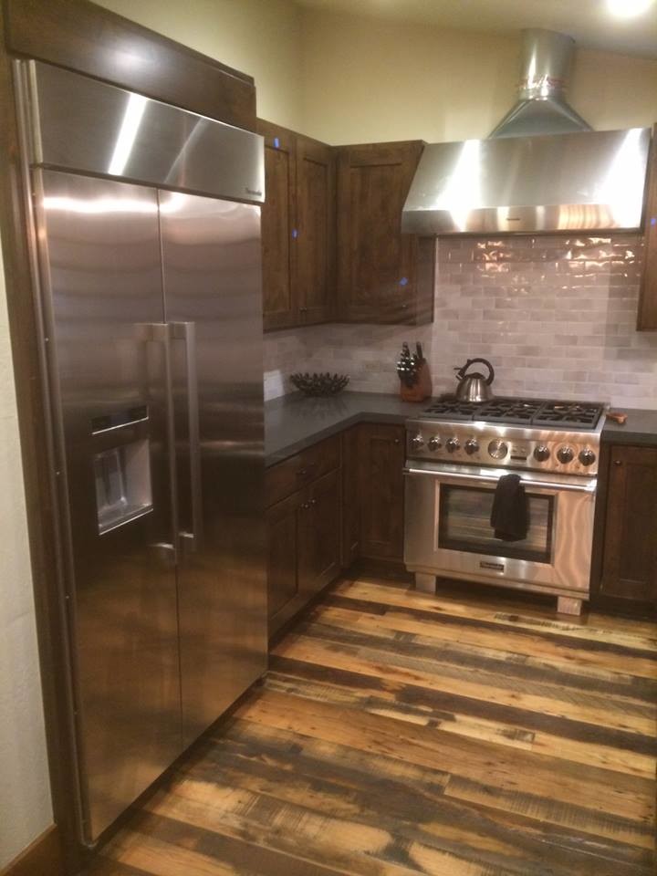Example of a small mountain style galley medium tone wood floor enclosed kitchen design in Sacramento with a drop-in sink, shaker cabinets, dark wood cabinets, granite countertops, white backsplash, porcelain backsplash, stainless steel appliances and no island