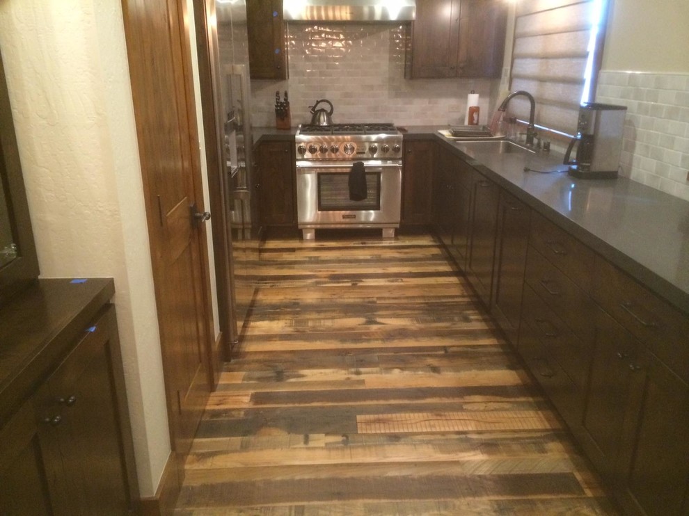 Small mountain style galley medium tone wood floor enclosed kitchen photo in Sacramento with a drop-in sink, shaker cabinets, dark wood cabinets, granite countertops, white backsplash, porcelain backsplash, stainless steel appliances and no island