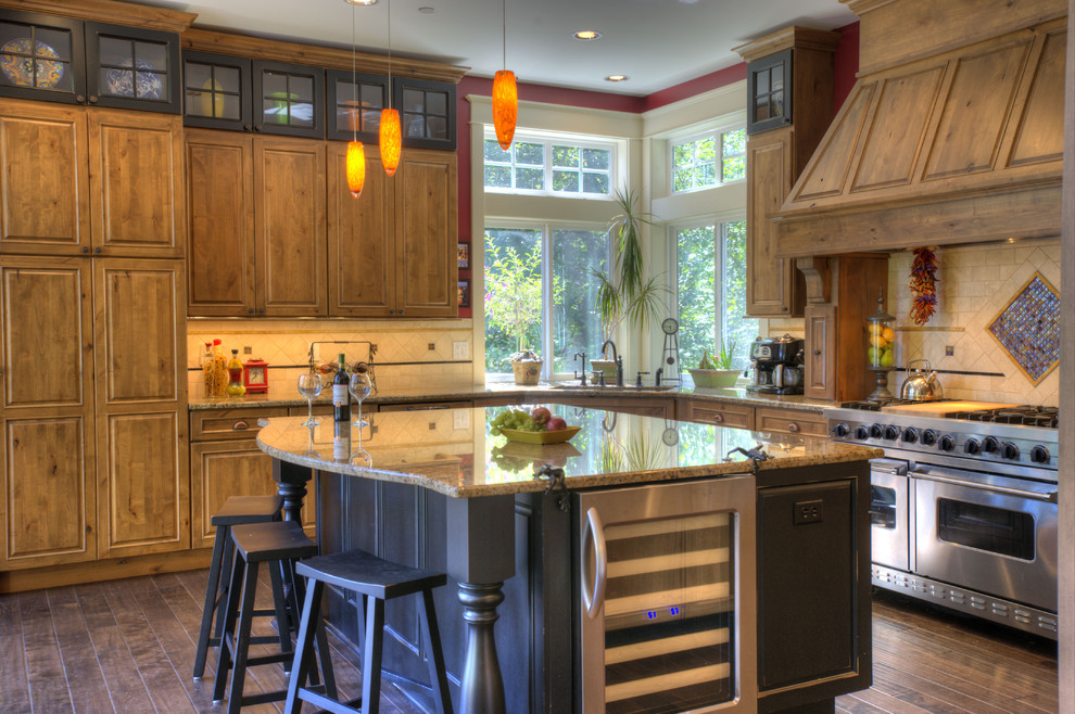 Cette photo montre une cuisine chic en L et bois brun avec un placard avec porte à panneau surélevé, une crédence beige et un électroménager en acier inoxydable.