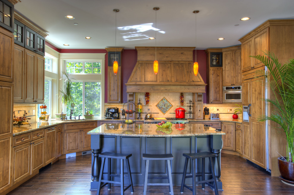 Traditional kitchen in Seattle with raised-panel cabinets, medium wood cabinets, multi-coloured splashback and integrated appliances.