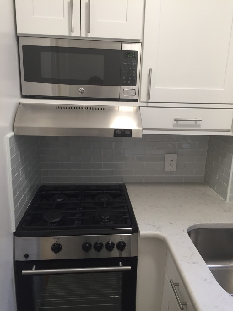 Example of a small trendy l-shaped porcelain tile eat-in kitchen design in New York with an undermount sink, shaker cabinets, white cabinets, quartz countertops, glass tile backsplash, stainless steel appliances and no island