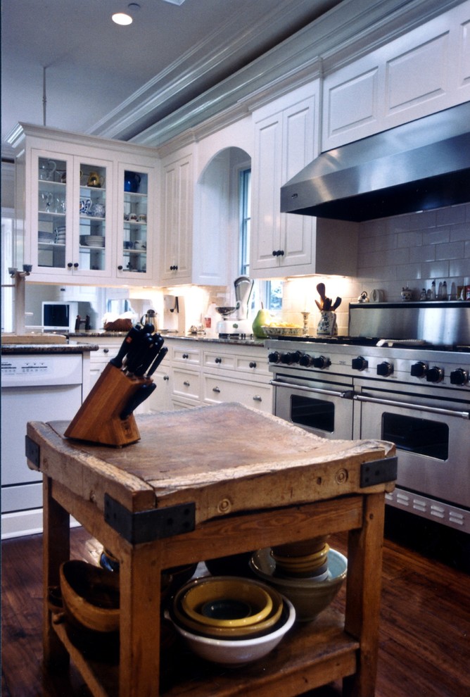 Huge elegant u-shaped medium tone wood floor eat-in kitchen photo in Los Angeles with a drop-in sink, recessed-panel cabinets, white cabinets, granite countertops, white backsplash, subway tile backsplash, stainless steel appliances and an island