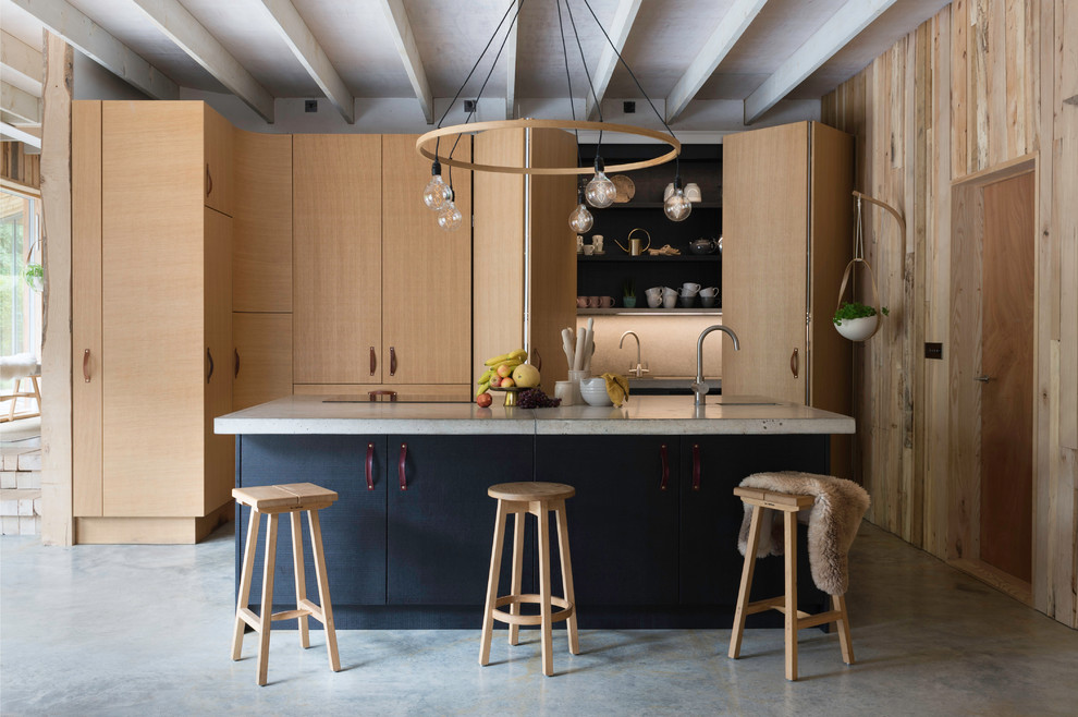 Zweizeilige Moderne Küche mit Unterbauwaschbecken, flächenbündigen Schrankfronten, hellen Holzschränken, Betonarbeitsplatte, Betonboden, Kücheninsel, grauem Boden und grauer Arbeitsplatte in Cornwall