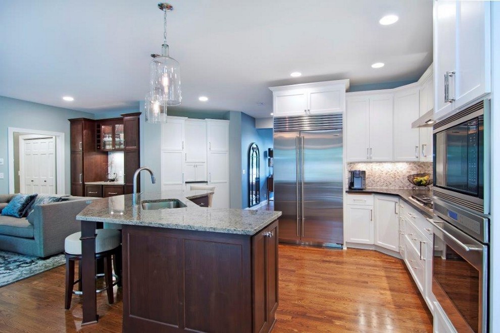 Modern inredning av ett mellanstort kök, med en undermonterad diskho, skåp i shakerstil, vita skåp, granitbänkskiva, flerfärgad stänkskydd, stänkskydd i stickkakel, rostfria vitvaror, mellanmörkt trägolv, en köksö och brunt golv