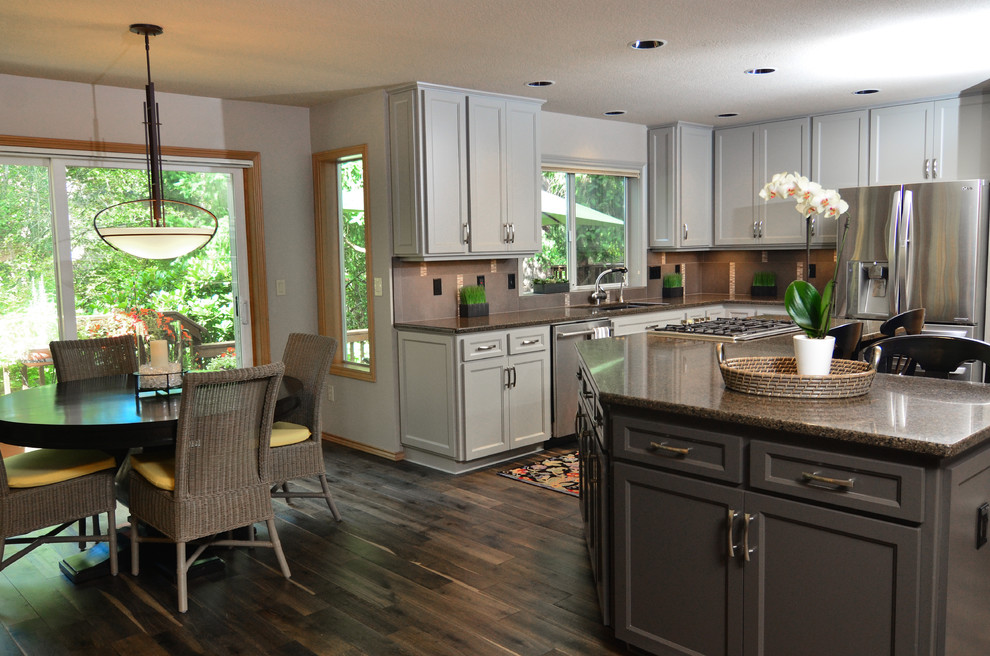 Example of a transitional eat-in kitchen design in Portland with an undermount sink, recessed-panel cabinets, gray cabinets, granite countertops, gray backsplash, stainless steel appliances and an island