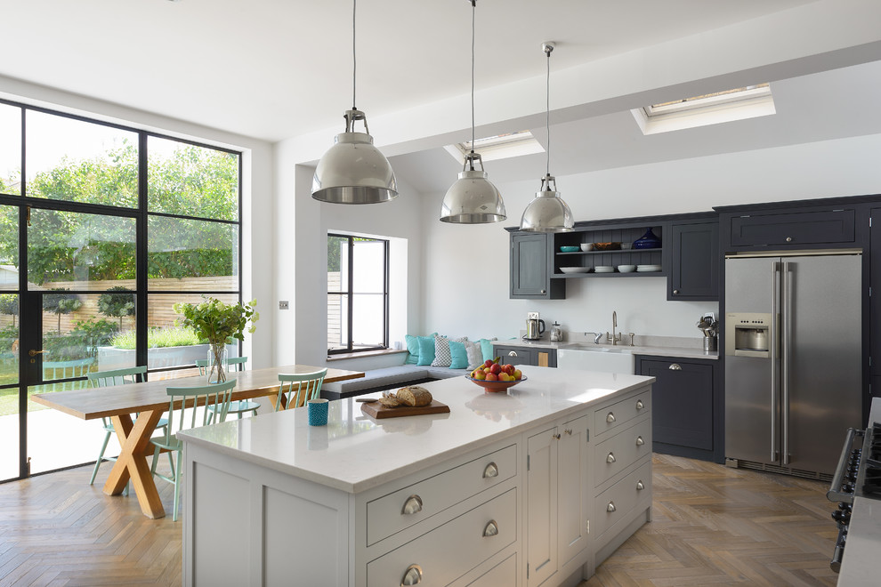 Inspiration for a mid-sized timeless eat-in kitchen remodel in London with shaker cabinets, dark wood cabinets, quartzite countertops and an island