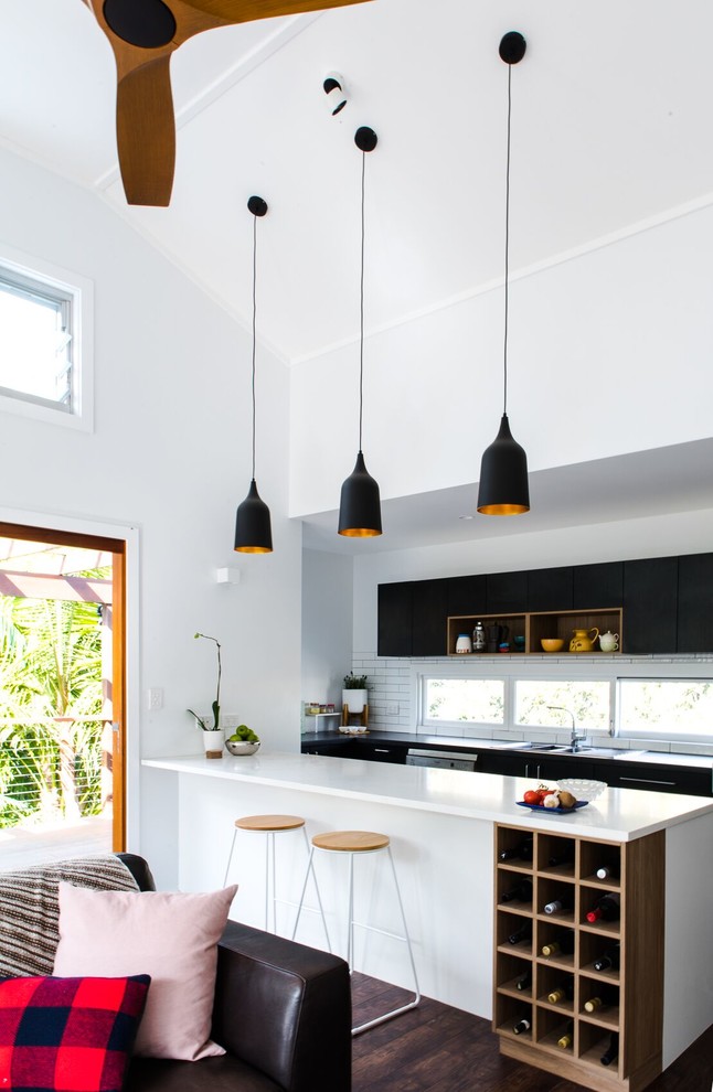Foto di una cucina design di medie dimensioni con lavello a doppia vasca, ante nere, paraspruzzi bianco, paraspruzzi con piastrelle diamantate, elettrodomestici in acciaio inossidabile, pavimento in vinile, pavimento marrone e top bianco