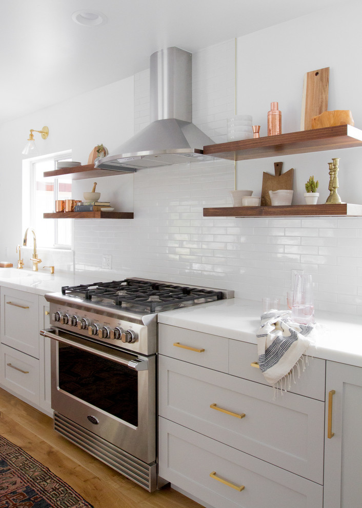 Klassisk inredning av ett mellanstort kök, med en dubbel diskho, skåp i shakerstil, grå skåp, marmorbänkskiva, vitt stänkskydd, stänkskydd i keramik, rostfria vitvaror, ljust trägolv och en halv köksö