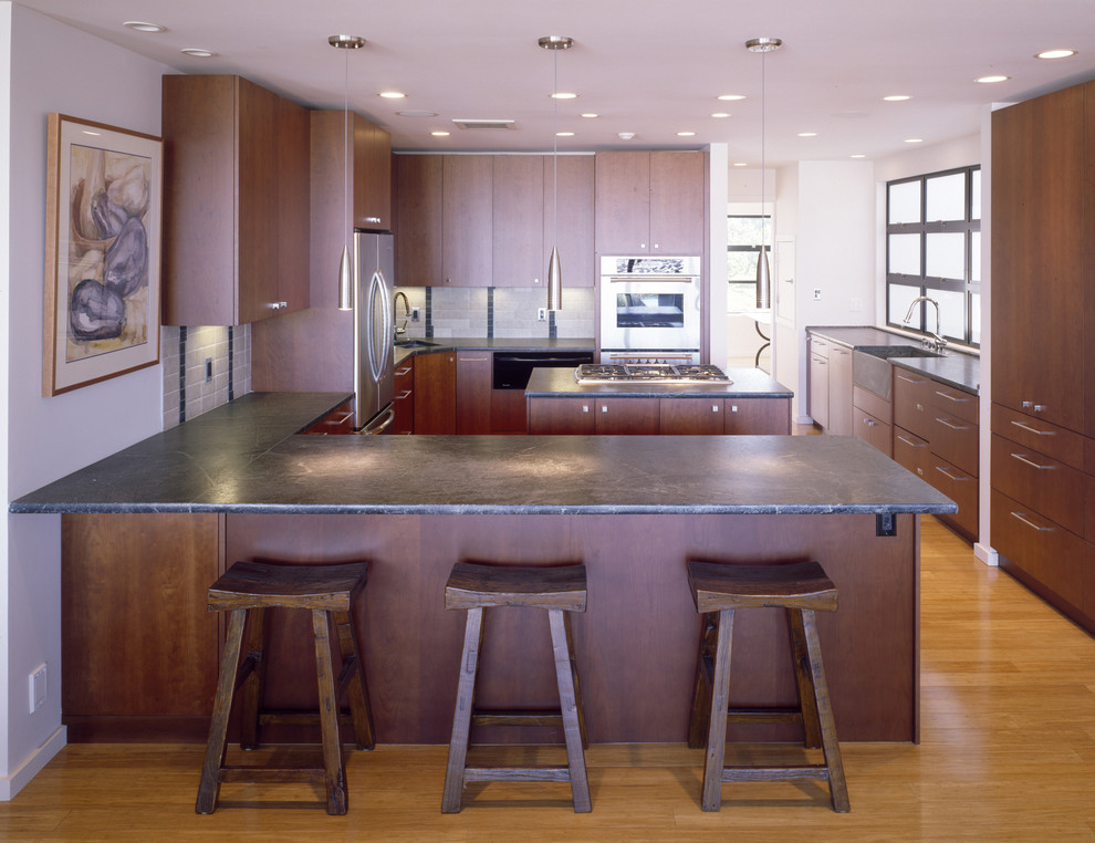 サンフランシスコにあるコンテンポラリースタイルのおしゃれなキッチン (シルバーの調理設備、エプロンフロントシンク、フラットパネル扉のキャビネット、濃色木目調キャビネット) の写真