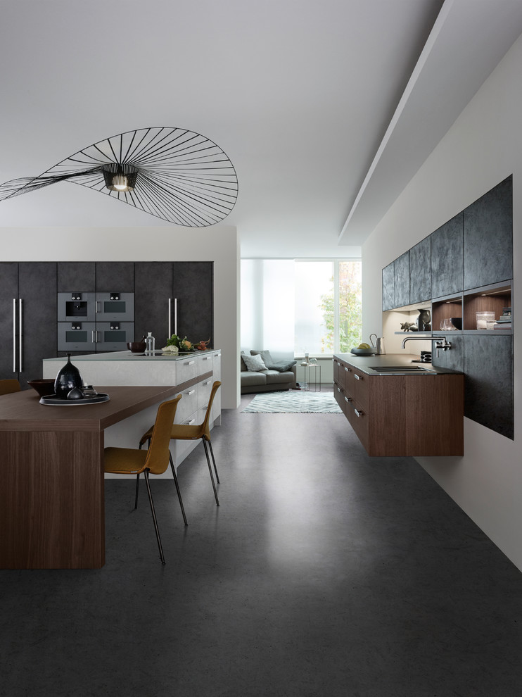 This is an example of a large contemporary l-shaped kitchen/diner in Orange County with a double-bowl sink, flat-panel cabinets, grey cabinets, glass worktops, white splashback, stainless steel appliances, concrete flooring and an island.