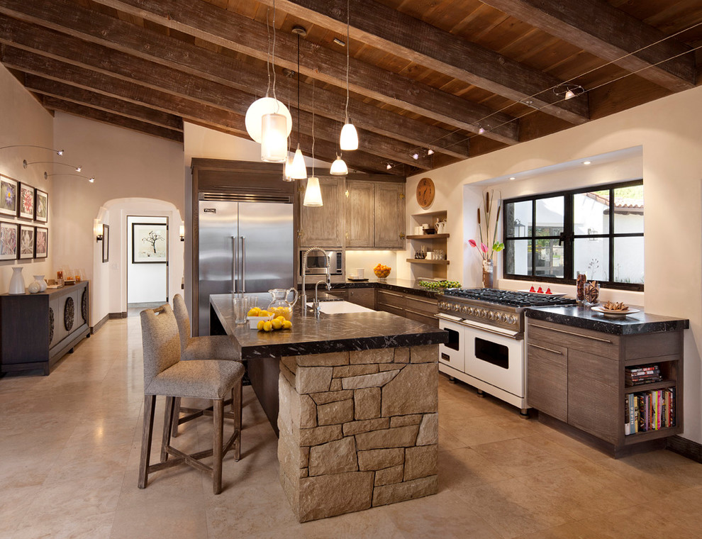 サンタバーバラにある地中海スタイルのおしゃれなL型キッチン (エプロンフロントシンク、オープンシェルフ、濃色木目調キャビネット、シルバーの調理設備) の写真
