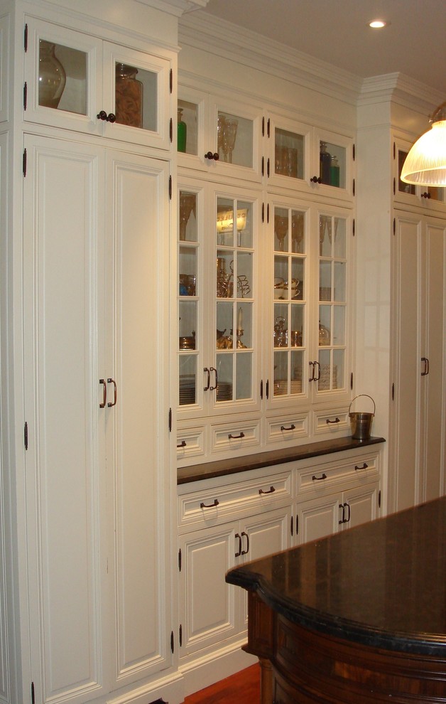 Example of a mid-sized classic u-shaped dark wood floor eat-in kitchen design in Toronto with recessed-panel cabinets, white cabinets, granite countertops, an island, an undermount sink, metallic backsplash and white appliances