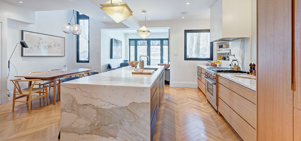 Idéer för ett mellanstort nordiskt vit linjärt kök och matrum, med en undermonterad diskho, släta luckor, skåp i ljust trä, marmorbänkskiva, vitt stänkskydd, stänkskydd i marmor, rostfria vitvaror, ljust trägolv, en köksö och beiget golv