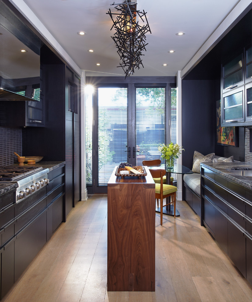 Diseño de cocina comedor contemporánea con armarios con paneles lisos, puertas de armario negras, salpicadero negro y electrodomésticos de acero inoxidable