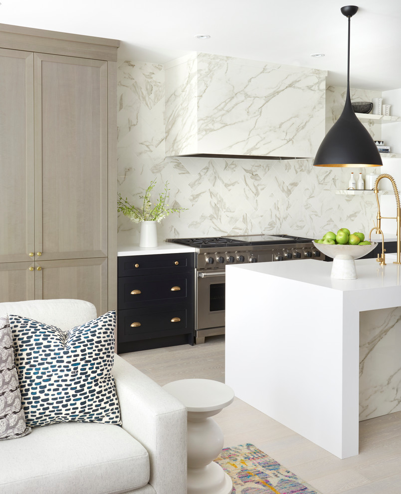 Foto på ett funkis kök med öppen planlösning, med flerfärgad stänkskydd, rostfria vitvaror, ljust trägolv och en köksö
