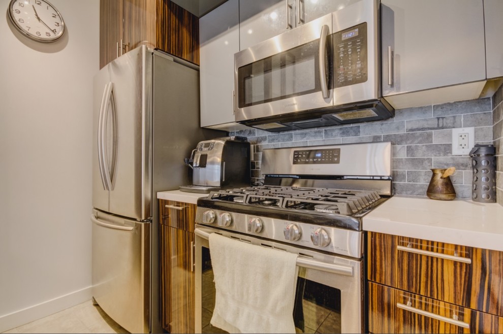 Exempel på ett mellanstort modernt vit vitt kök, med en undermonterad diskho, släta luckor, bänkskiva i kvarts, grått stänkskydd, stänkskydd i cementkakel, rostfria vitvaror, en halv köksö, bruna skåp, plywoodgolv och grått golv