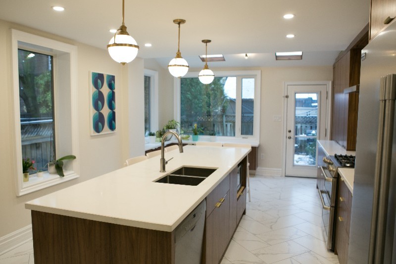 Foto på ett mellanstort funkis vit linjärt kök och matrum, med en undermonterad diskho, släta luckor, skåp i mörkt trä, bänkskiva i kvartsit, vitt stänkskydd, stänkskydd i keramik, rostfria vitvaror, marmorgolv, en köksö och vitt golv