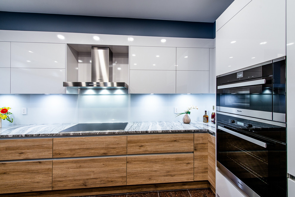 Immagine di una cucina design chiusa e di medie dimensioni con lavello a doppia vasca, ante lisce, top in quarzo composito, paraspruzzi bianco e elettrodomestici in acciaio inossidabile