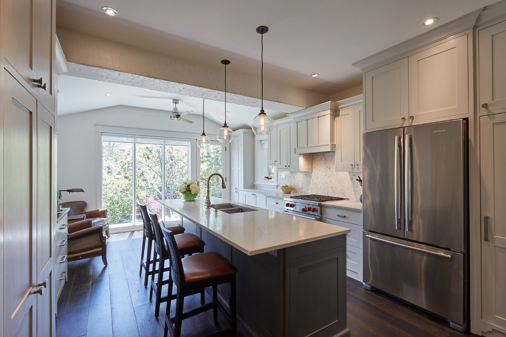 Medium sized classic galley kitchen pantry in Toronto with a submerged sink, shaker cabinets, grey cabinets, engineered stone countertops, grey splashback, stone tiled splashback, stainless steel appliances, dark hardwood flooring, an island and brown floors.