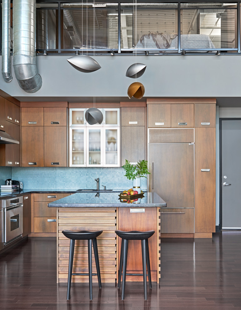 Example of a mid-sized urban l-shaped dark wood floor and brown floor open concept kitchen design in Toronto with an undermount sink, flat-panel cabinets, medium tone wood cabinets, granite countertops, blue backsplash, glass sheet backsplash, stainless steel appliances and an island