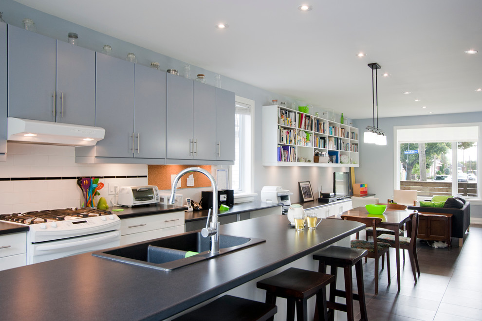 Offene, Zweizeilige Moderne Küche mit flächenbündigen Schrankfronten, grauen Schränken, Küchenrückwand in Weiß, Rückwand aus Metrofliesen, weißen Elektrogeräten und Einbauwaschbecken in Toronto