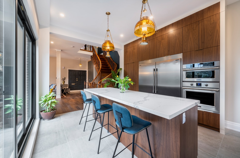 Photo of a medium sized contemporary l-shaped enclosed kitchen in Toronto with a submerged sink, flat-panel cabinets, medium wood cabinets, marble worktops, white splashback, marble splashback, stainless steel appliances, porcelain flooring, an island, grey floors and white worktops.