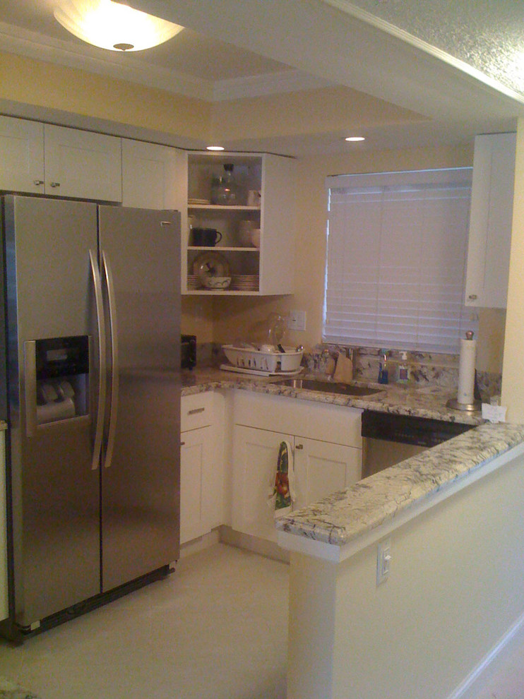 Inspiration for a timeless u-shaped eat-in kitchen remodel in Miami with an undermount sink, shaker cabinets, white cabinets, granite countertops, white backsplash and stainless steel appliances