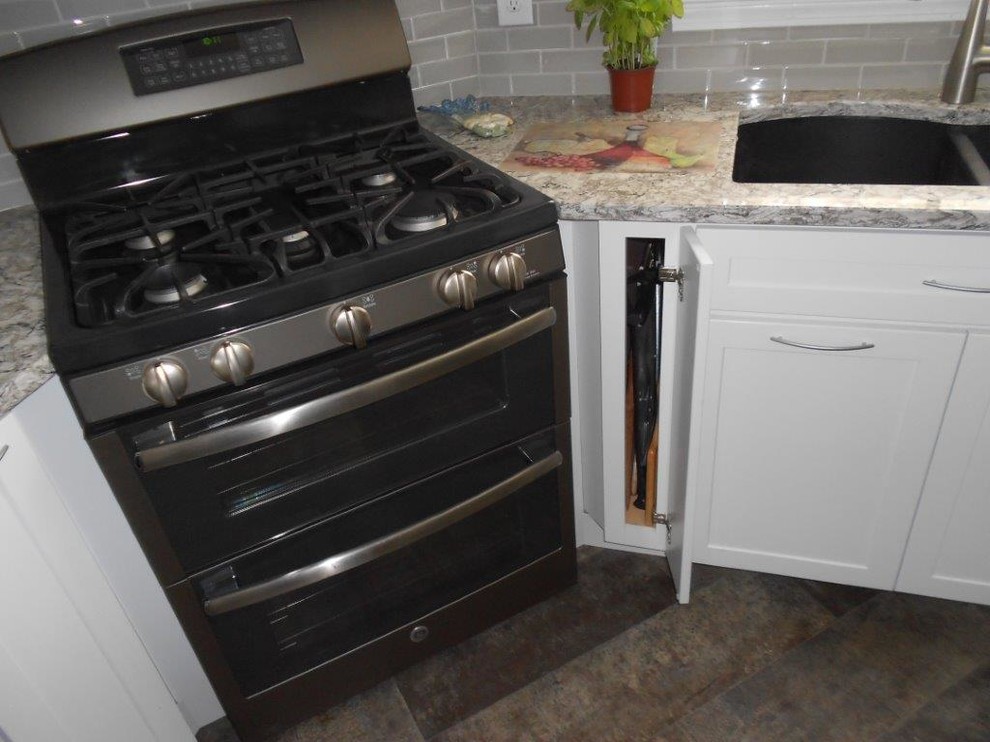 Medium sized classic u-shaped kitchen/diner in Portland Maine with a submerged sink, shaker cabinets, white cabinets, granite worktops, grey splashback, metro tiled splashback, stainless steel appliances, slate flooring and an island.