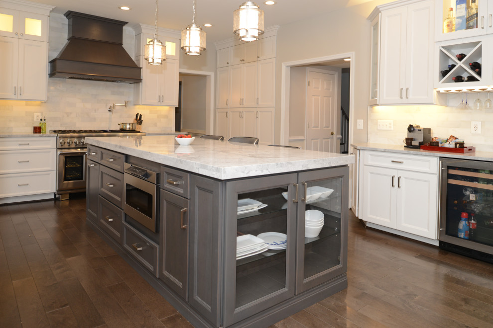 Modern inredning av ett mellanstort vit vitt kök och matrum, med luckor med profilerade fronter, vita skåp, granitbänkskiva, vitt stänkskydd, rostfria vitvaror, en köksö och brunt golv